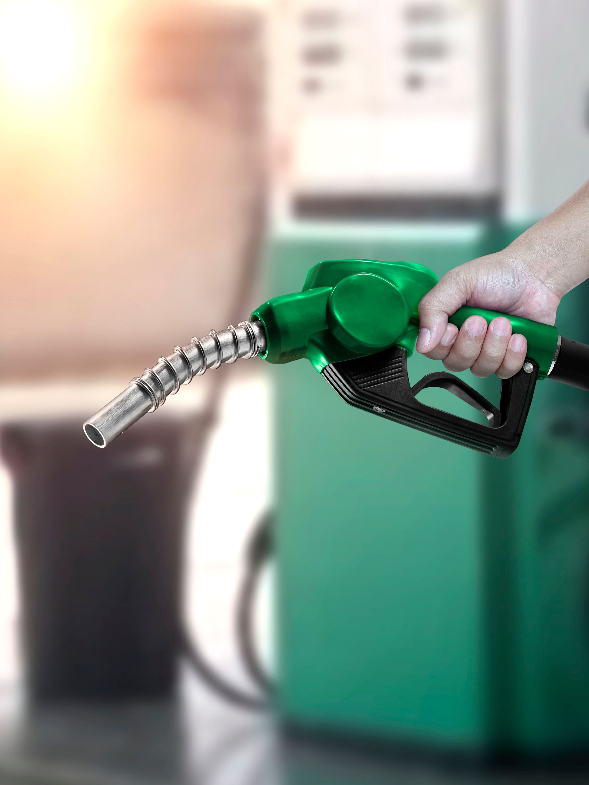 Man holding fuel nozzle at gas station